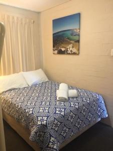 a bedroom with a bed with two towels on it at RIVERVIEW HOLIDAY APARTMENTS Formerly Kalbarri Beach Resort in Kalbarri