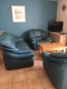 a living room with two leather chairs and a table at Riverview Holliday villa with River Views and Pool in Kalbarri +13 photos
