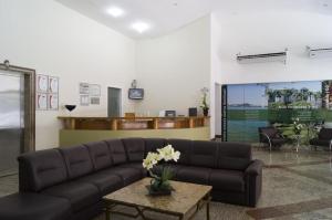 a living room with a couch and a table at Apart Guarapari Residence - Areia Preta in Guarapari