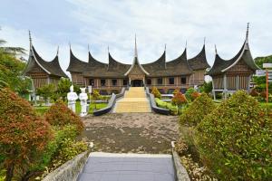 un grand bâtiment avec des toits pointus dans un jardin dans l'établissement Whiz Prime Hotel Khatib Sulaiman Padang, à Padang