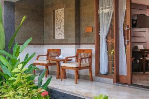 eine Terrasse mit 2 Stühlen, einem Tisch, einem Tisch und Stühlen in der Unterkunft Bali Tropic Resort & Spa - CHSE Certified in Nusa Dua