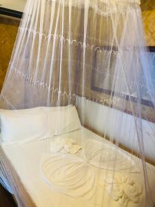 a bed with white sheets and onions on it at Ced Pension in El Nido