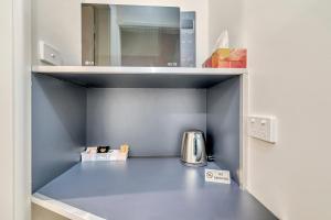 a kitchen counter with a microwave and a cupboard at Surf Beach Motel Port in Port Macquarie
