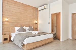sypialnia z dużym łóżkiem i drewnianą ścianą w obiekcie Vann House Hua Hin w mieście Hua Hin
