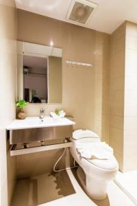 La salle de bains est pourvue de toilettes et d'un lavabo. dans l'établissement D Day Suite, à Bangkok