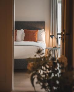 een slaapkamer met een bed met oranje en witte kussens bij Hame on Skye in Lonmore