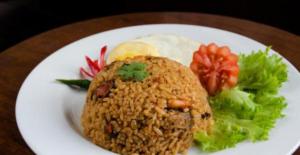 a white plate of food with rice and vegetables at HENDRO'S SURF CAMP Pulau merah in Pasanggaran