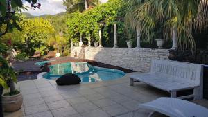 a bench sitting on a patio next to a swimming pool at Chalet De Tahiti in Punaauia