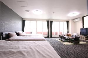 a hotel room with three beds and a flat screen tv at Apartment Susukino Hakuhou Building in Sapporo