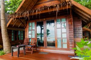 a cabin with two chairs and a table on a deck at Lipe Beach Resort in Ko Lipe