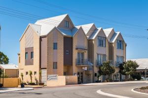 an apartment building with solar panels on the roof at Serenity on the Terrace in Mandurah