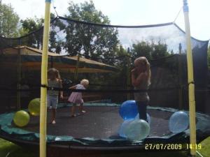 a woman and two children playing on a trampoline at Vētrasputns in Mērsrags