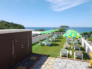 een rij stoelen en parasols op een balkon bij Kata Beachwalk Hotel and Bungalows in Kata Beach