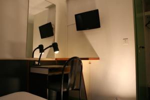 Habitación con escritorio, lámpara y espejo. en Hôtel La Chartreuse en Toulouse