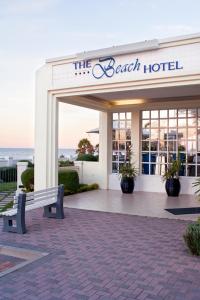 a beach hotel with a bench in front of it at The Beach Hotel in Port Elizabeth