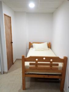 Bett in einem Zimmer mit einer weißen Wand in der Unterkunft San San Andrés Little House 3 by BBBSAI in San Andrés