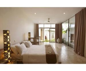 a bedroom with a large bed and a large window at Sunset Paradise Villa Uluwatu in Uluwatu