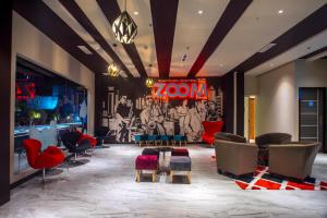 a lobby with chairs and a wall with a mural at Zoom Hotel Mulawarman in Samarinda