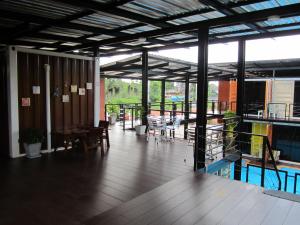 a room with a deck with tables and chairs at Retro Box Hotel Chumphon in Chumphon