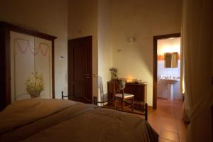 a bedroom with a bed and a table and a bathroom at Monastero Di Sant'Erasmo in Veroli