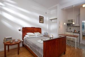 a bedroom with a bed and a small kitchen at Royal Route Place for You in Warsaw