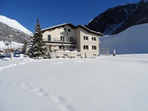Apart Tyrol في امهاوسن: مبنى في الثلج مع شجرة عيد الميلاد