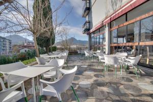 a patio with white tables and chairs on a building at Hotel San Blas in Abadiano Celayeta
