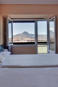 um quarto com uma cama e uma grande janela em Hotel San Blas em Abadiano Celayeta