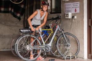 un hombre está de pie junto a una bicicleta en Pension Monika, en Lagundo