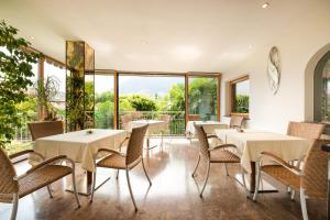 a restaurant with tables and chairs and a balcony at Pension Monika in Lagundo