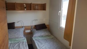 two beds in a small room with a window at Mobile Home Pearl of Murter in Jezera
