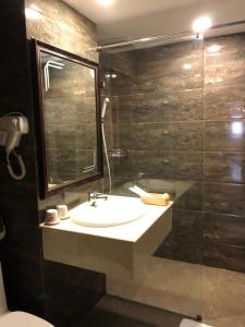y baño con lavabo y ducha acristalada. en Phung Long Hotel, en Ho Chi Minh
