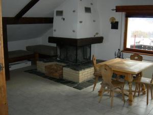 un soggiorno con camino, tavolo e sedie di Jambo a Valchava