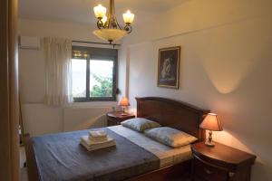1 dormitorio con 1 cama con 2 lámparas y una ventana en Holy Paraskevi Apartment, en Agios Nikolaos