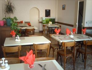 un ristorante con tavoli e sedie con fiocchi rossi sopra di Hotel Le Colbert epernay a Épernay