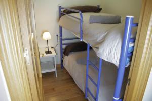 ein Schlafzimmer mit einem Etagenbett mit blauen Etagenbetten in der Unterkunft Miramar Ski a pie de pista - Apartamento Deluxe, 4 habitaciones in Sierra Nevada + 12 Fotos