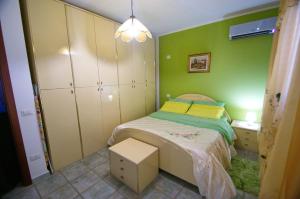 a small bedroom with a bed and green walls at Il Fenicottero in Masainas