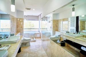 Un baño grande con dos lavabos y dos inodoros. en The Sintesa Jimbaran Bali, en Jimbaran