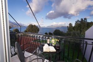 a balcony with a table and chairs and a view of the water at Dimitris Studios in Karavomylos
