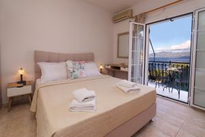 a bedroom with a bed and a balcony with a view at Dimitris Studios in Karavomylos