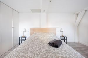 リールにあるCoeur de Lille - cosy appartement 5のベッドルーム(白い大型ベッド、ランプ2つ付)