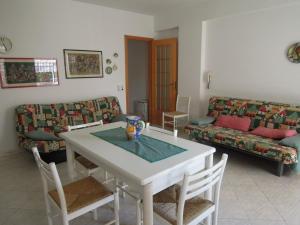 - un salon avec une table et un canapé dans l'établissement Appartamento In Riva Al Mare con Posto Auto E Disponibilità Bicicletta, à Mascali