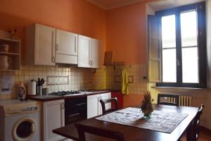 a kitchen with a table and a sink and a stove at Il Glicine Apartment Rimini in Rimini
