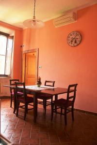 里米尼的住宿－Il Glicine Apartment Rimini，餐桌、椅子和墙上的时钟