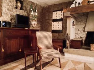 a living room with a chair and a fireplace at Casa al Riccio in Capolona