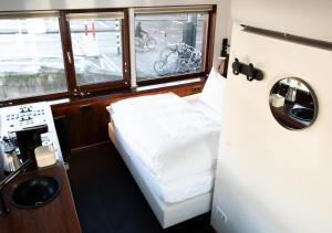 Habitación pequeña con cama y ventana en SWEETS - Zeilstraatbrug en Ámsterdam
