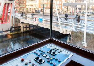 a room with a table with cups and a view of a bridge at SWEETS - Zeilstraatbrug in Amsterdam