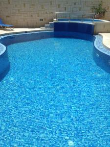 una gran piscina azul en un edificio en Angelica Studios and Apartments en Agia Marina Nea Kydonias