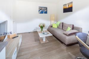 ein Wohnzimmer mit einer Couch und einem Tisch in der Unterkunft Ferienhaus an der Karlstraße in Norderney