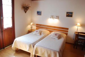a hotel room with two beds and a desk at La Gelinotte in Les Contamines-Montjoie